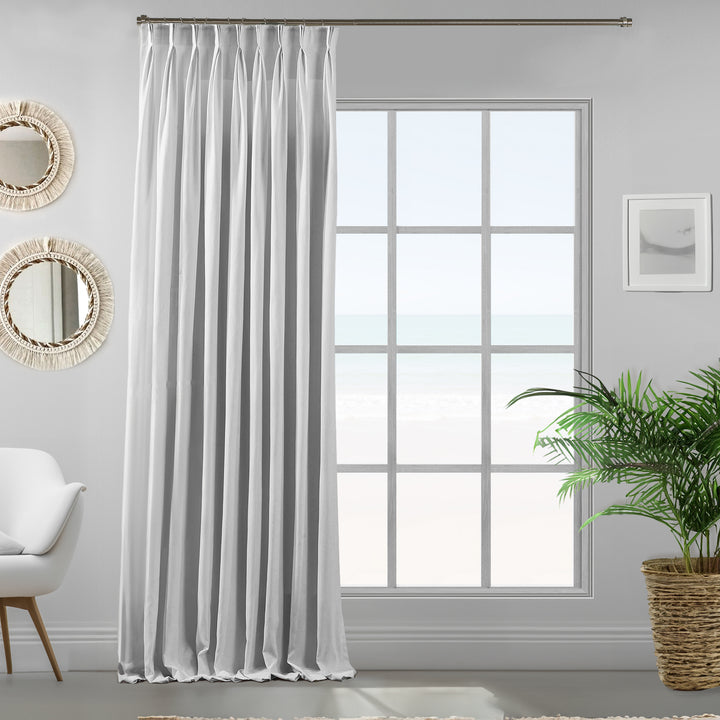 Pure white velour curtains photographed from an angle, showing soft drape, matte finish and refined texture.