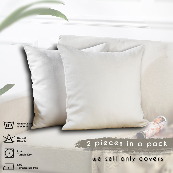 Two white pillowcases on a light-colored sofa with care instructions displayed.