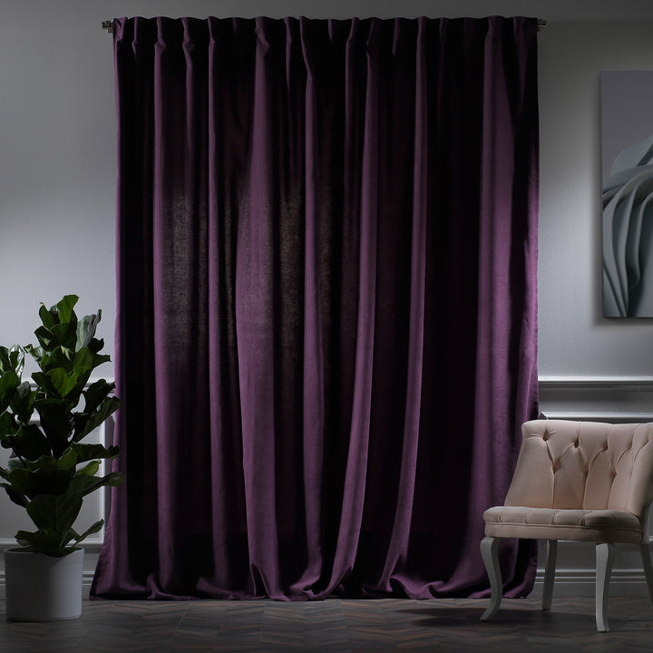 Purple velour curtains photographed at night, showing deep tone, smooth pile texture and elegant tailored fall, made to measure and available by the metre.
