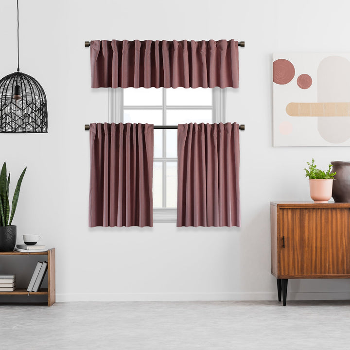 Set of maroon curtains with a valance in a room with a wooden sideboard and decor items.