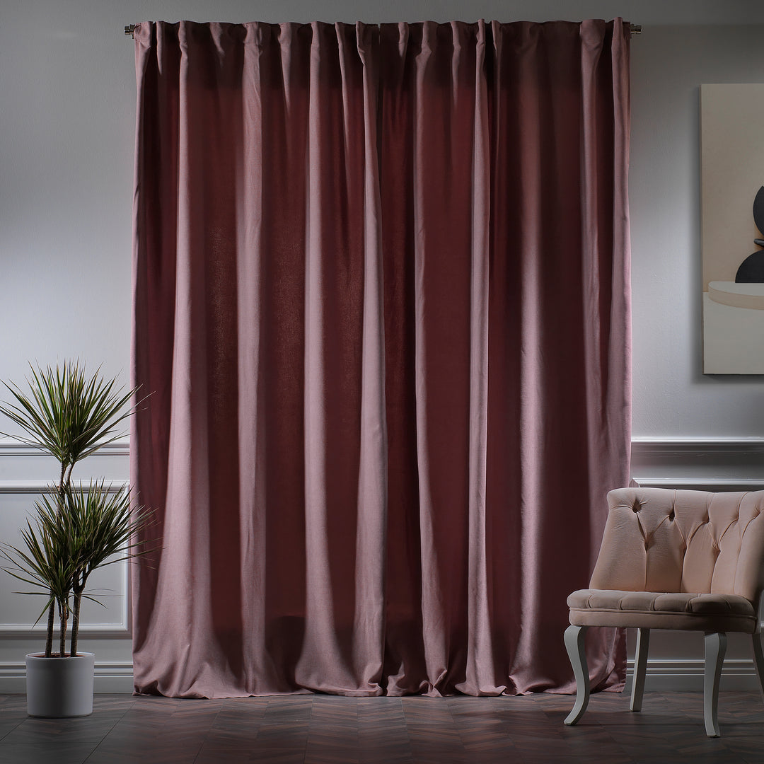 Rose pink velour curtains photographed at night, showing deep warm tone, dense weave and refined matte finish, made to measure and available by the metre.