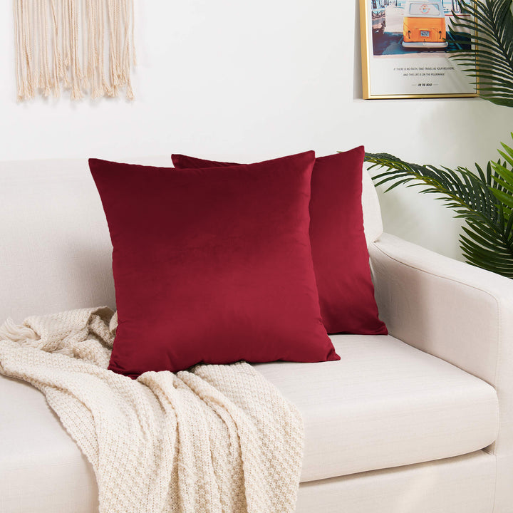 A made to measure cushion cover in vibrant ruby‑red shiny velvet, shown with a smooth reflective sheen and crisp tailored edges for a striking premium style