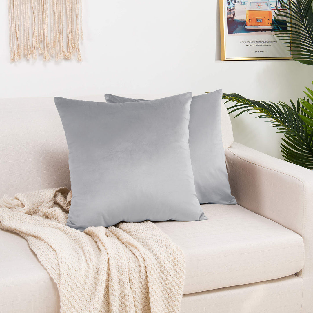A made to measure cushion cover in light silver‑grey shiny velvet, displaying a smooth glossy texture and crisp seams for a bright elegant appearance