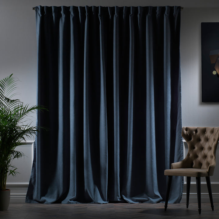 Sky blue velour curtains photographed at night, showing soft cool tone, smooth pile and elegant drape, made to measure and available by the metre.