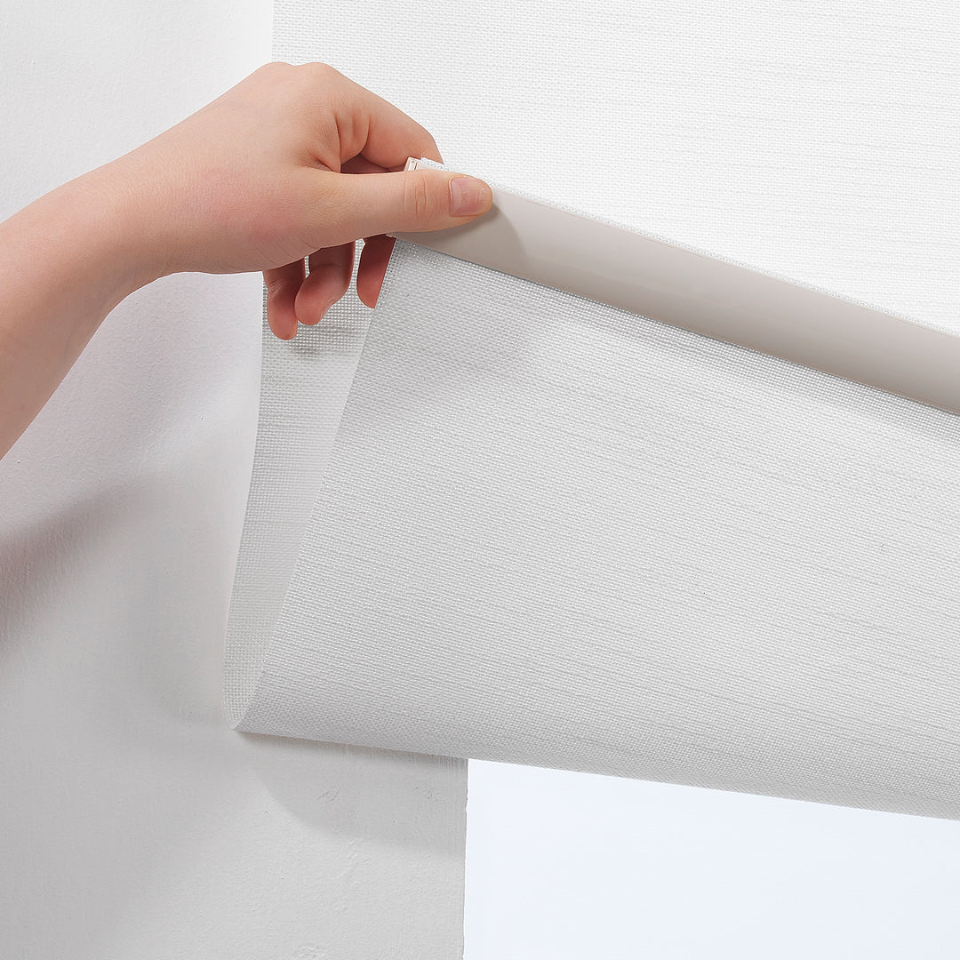 White daylight roller blind with a minimal linen‑effect pattern and a calm, even glow.