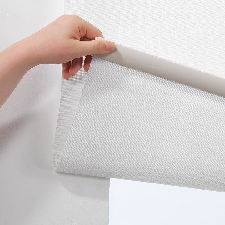 White daylight roller blind with a minimal linen‑effect pattern and a calm, even glow.