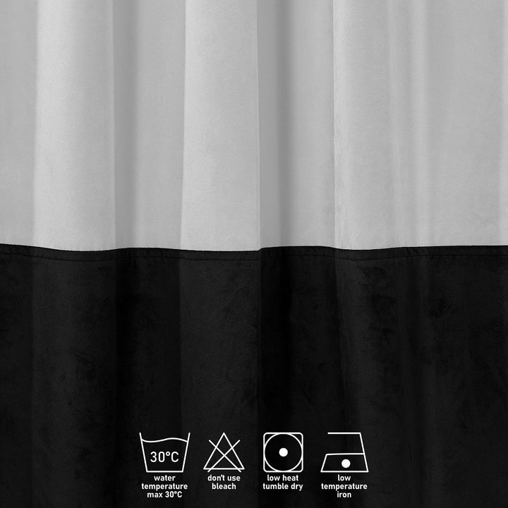 A close‑up of a white and black matte velvet block curtain, highlighting the soft texture and crisp two‑tone division