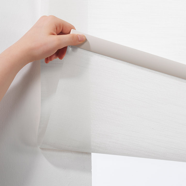 A white linen‑look room darkening roller blind made to measure, shown lowered with a soft woven texture and clean minimal edges